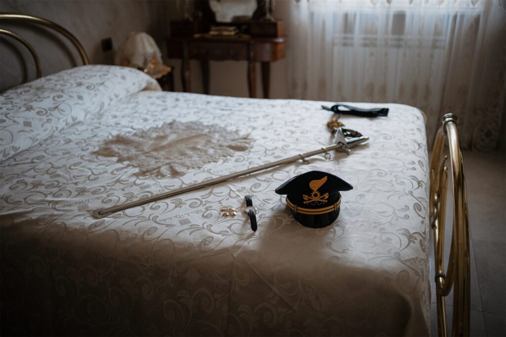 Divisa, cappello e sciabola dello sposo sul letto, preparativi di un matrimonio a Napoli