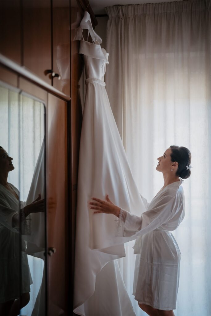 L'abito da sposa appeso accanto alla finestra
