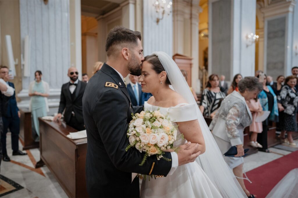 Lo sposo bacia la sposa sulla fronte durante la cerimonia nella Basilica di Capodimonte, Napoli