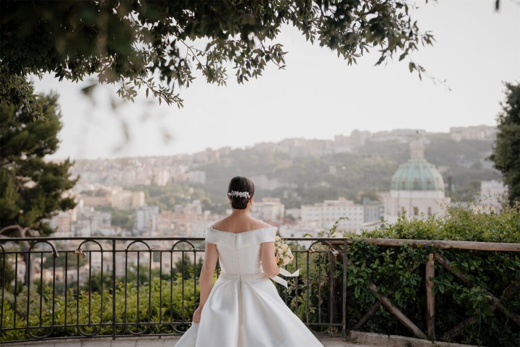 La sposa di spalle guarda il panorama sulla città dal Real Bosco di Capodimonte, Napoli