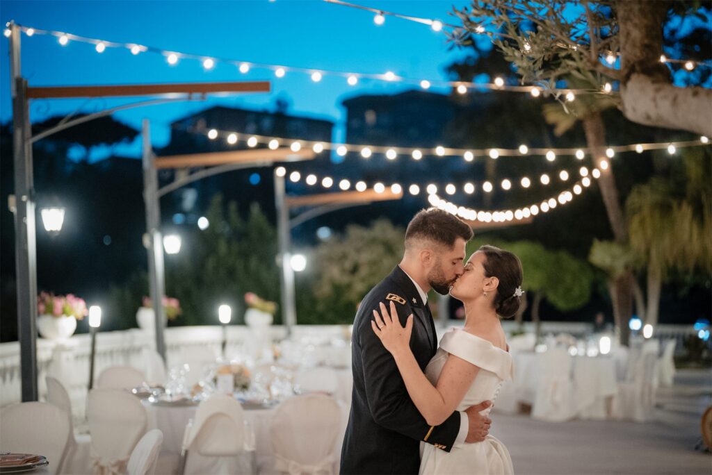 Il bacio degli sposi sulla terrazza illuminata a Villa Cilento, Posillipo (Napoli)