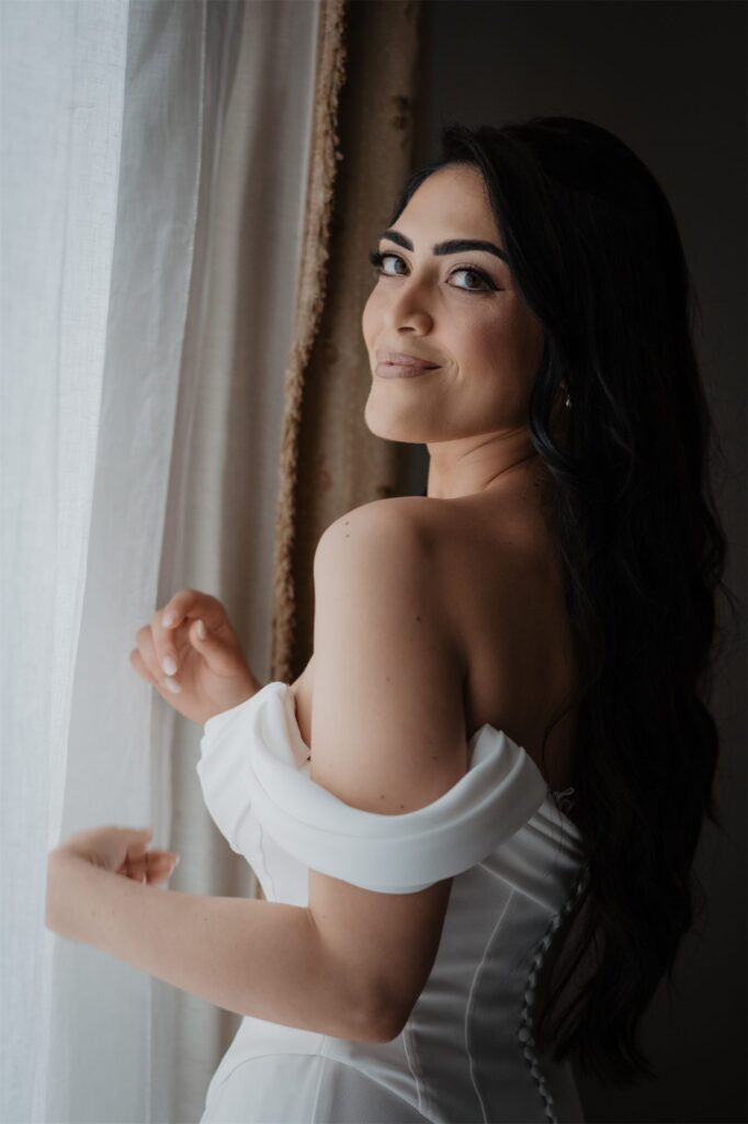 La sposa alla finestra in abito da sposa