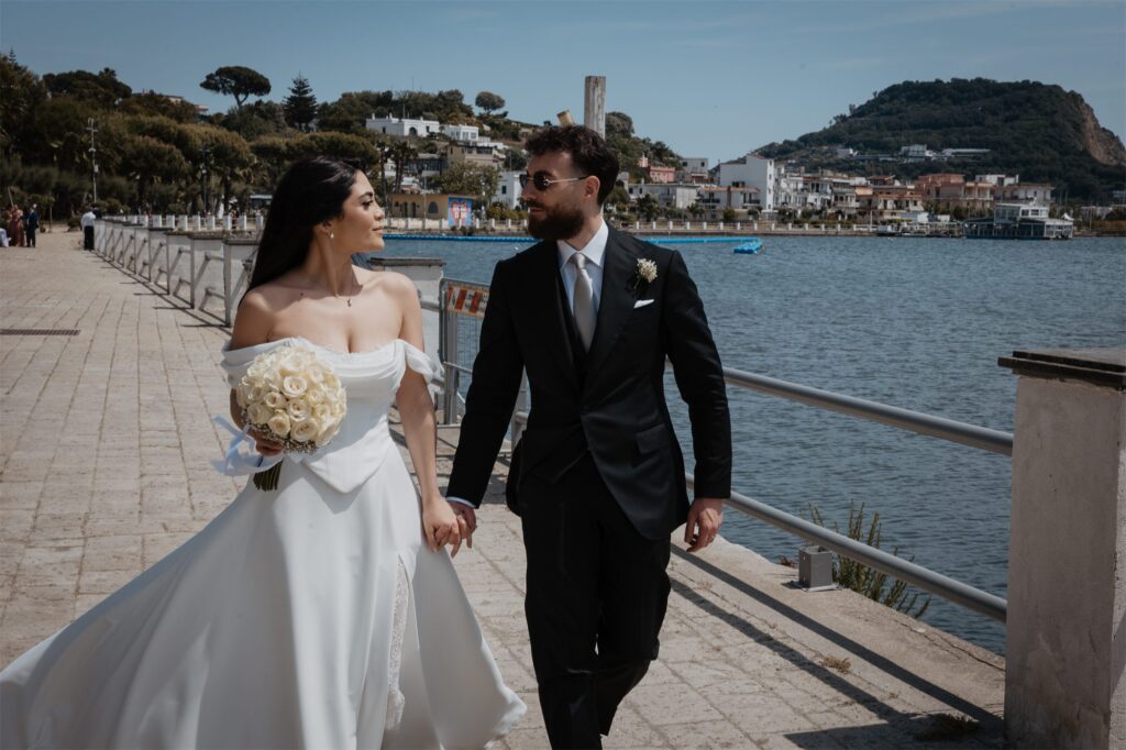 Gli sposi passeggiano sul lungomare di Bacoli