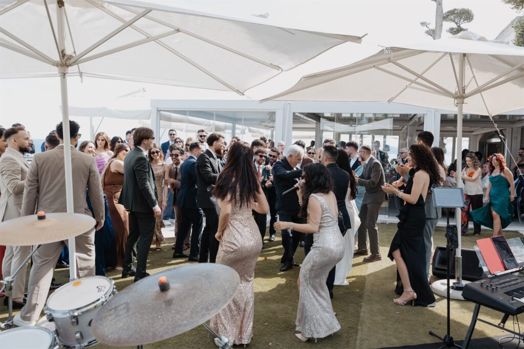 Gli invitati ballano sotto gli ombrelloni