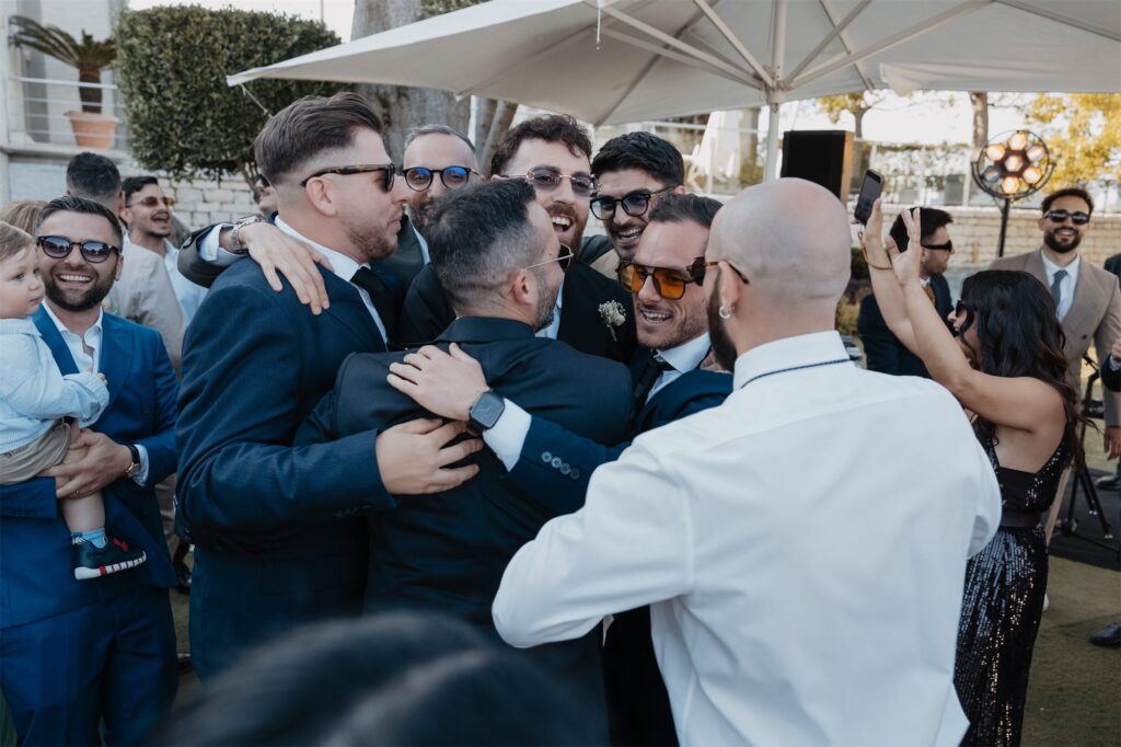 Gli amici sollevano lo sposo in festa