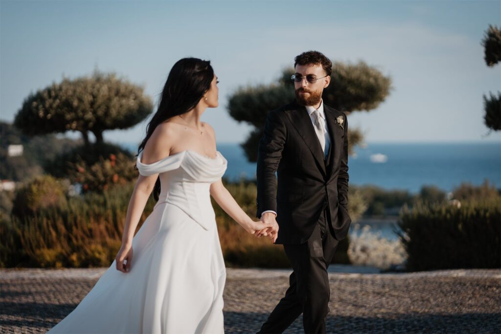 Gli sposi mano nella mano al tramonto a Villa Punta Pennata