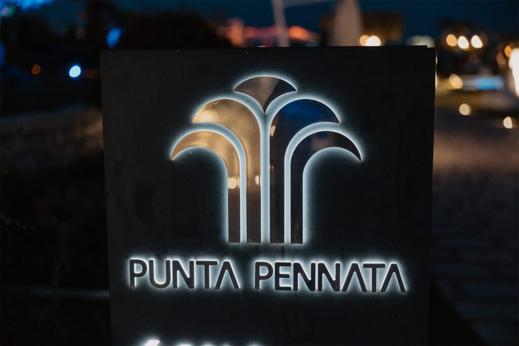 L'insegna di Villa Punta Pennata illuminata di sera