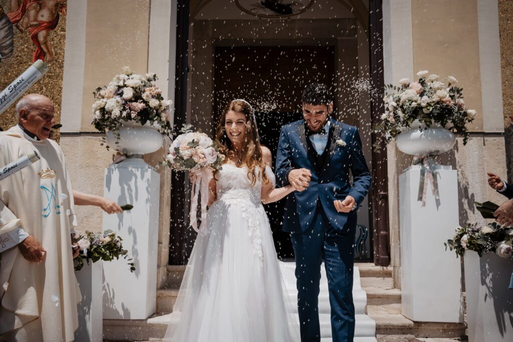 Gli sposi escono dalla chiesa tra il lancio del riso