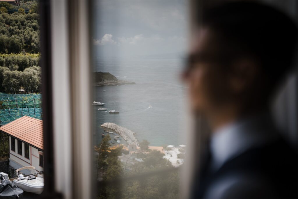 Il mare di Massa Lubrense riflesso nella finestra con lo sposo