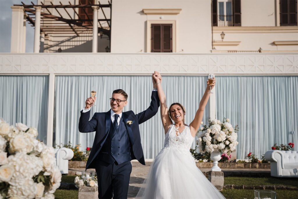 Gli sposi alzano le braccia all'ingresso degli invitati