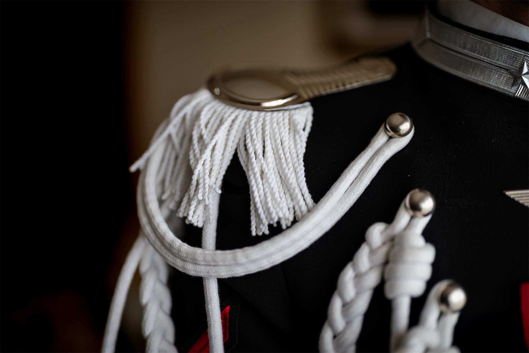 Dettaglio della spallina con i cordoni bianchi dell'uniforme dello sposo
