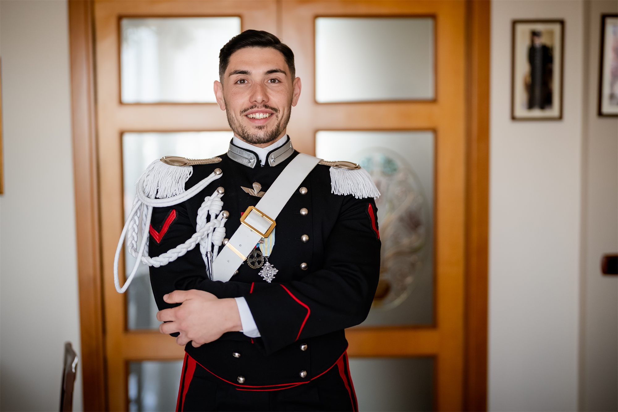 Ritratto dello sposo in alta uniforme da carabiniere davanti alla porta di casa