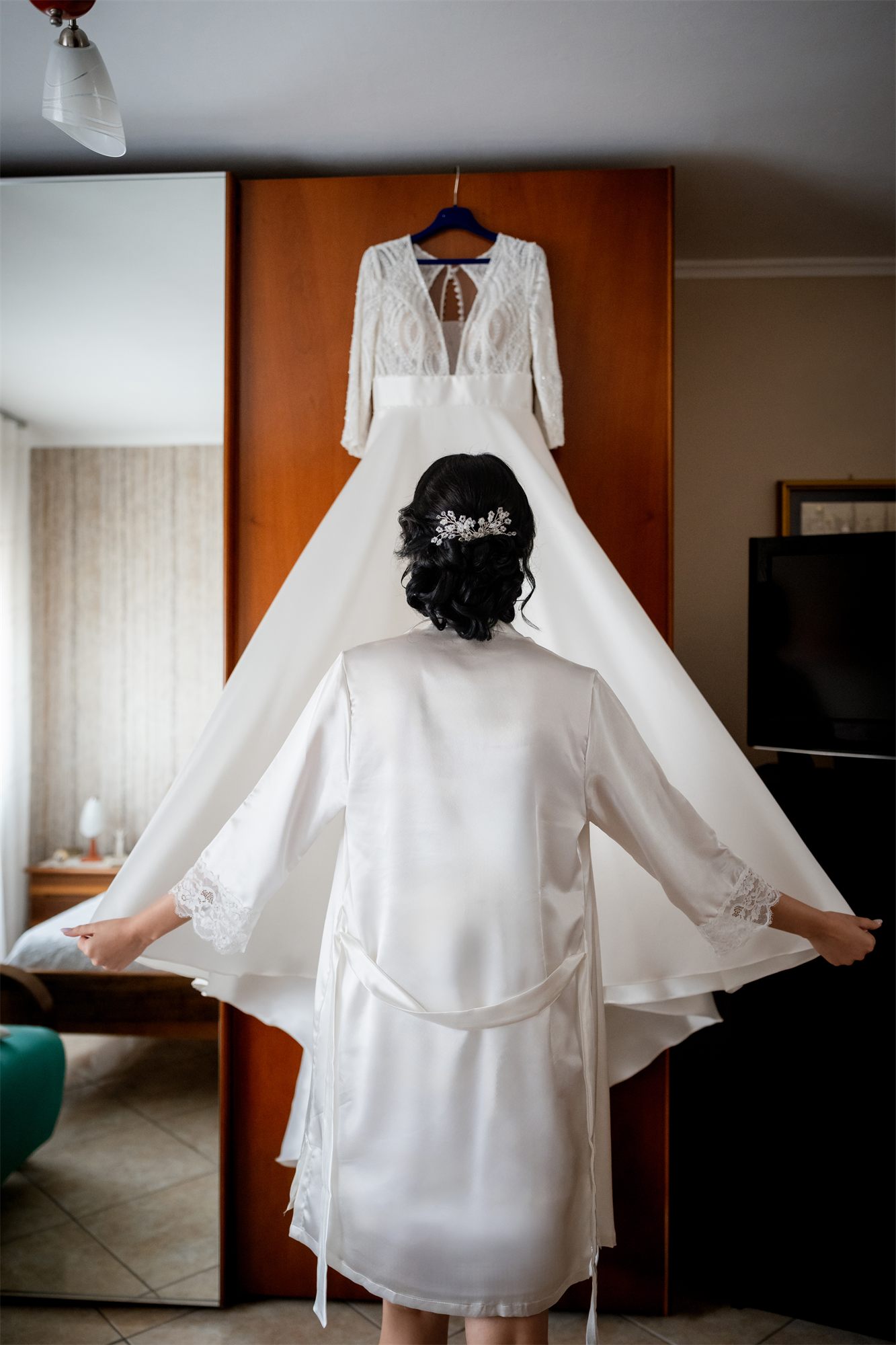 L'abito da sposa appeso nella camera, mentre la sposa si prepara