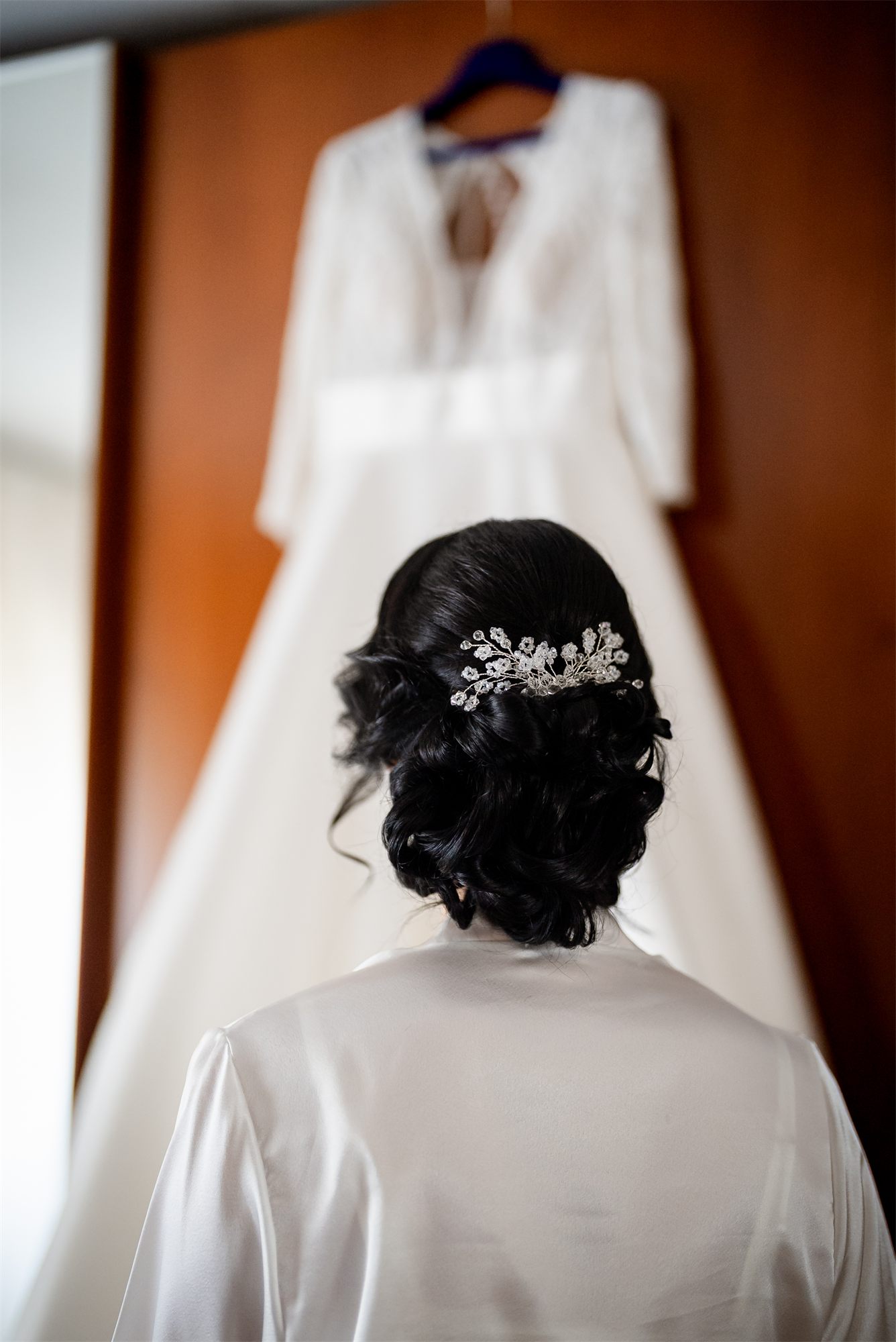 L'acconciatura della sposa e l'abito appeso, visti da dietro