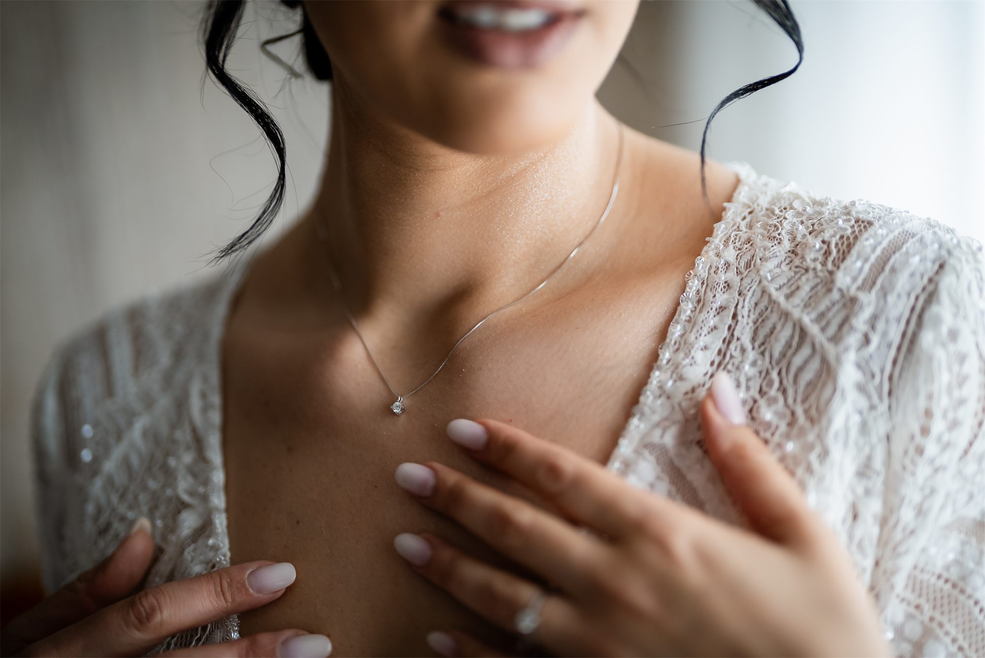 Dettaglio della collana e del pizzo dell'abito della sposa