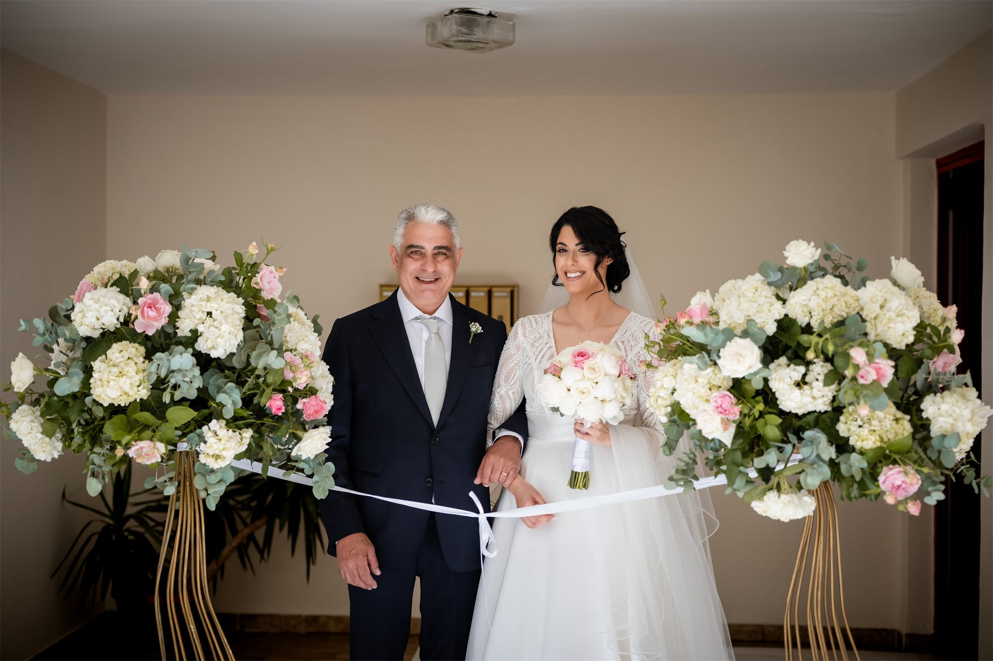 Il taglio del nastro con il papà all'uscita di casa della sposa