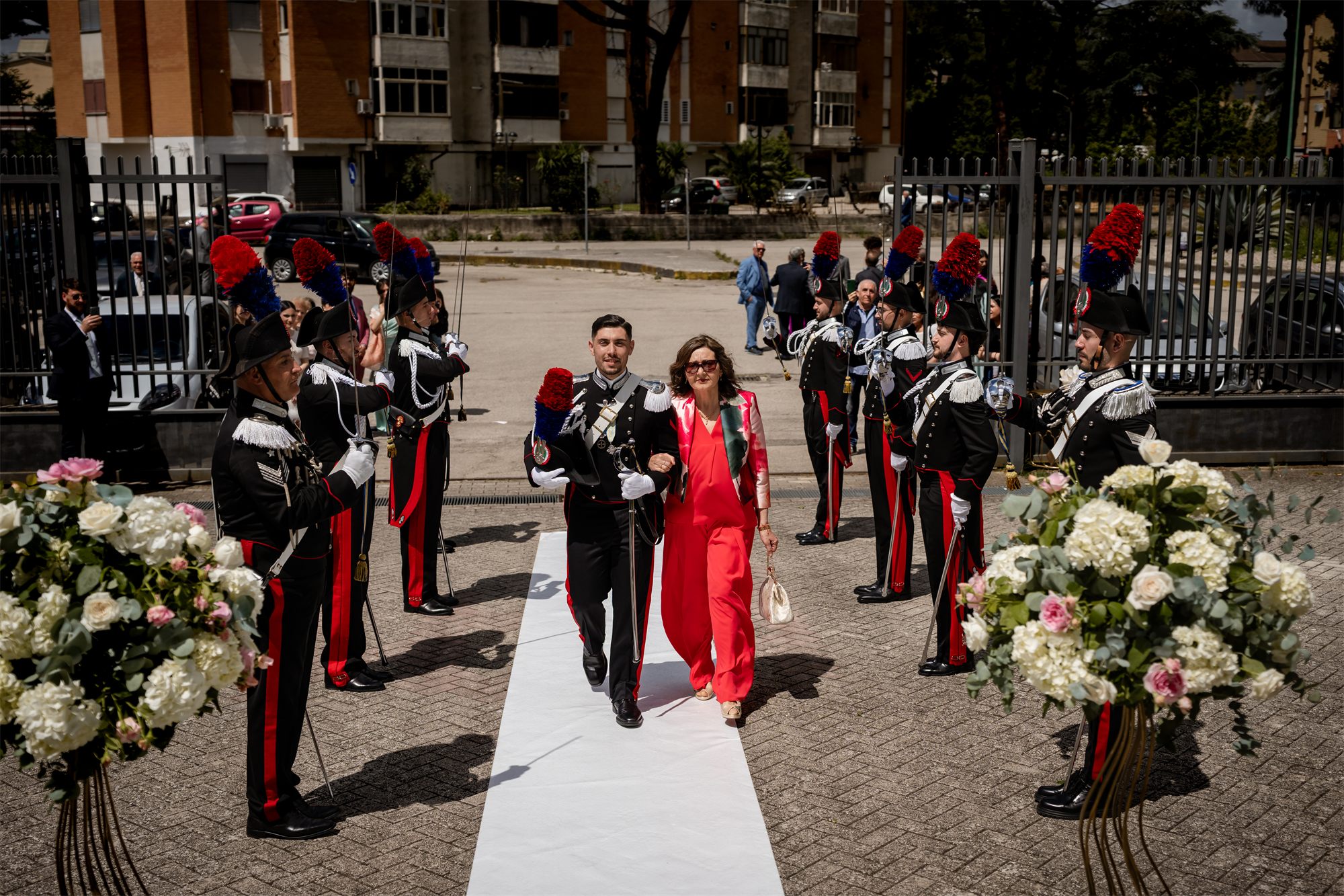 Lo sposo in uniforme entra in chiesa accompagnato dalla mamma, tra due ali di carabinieri