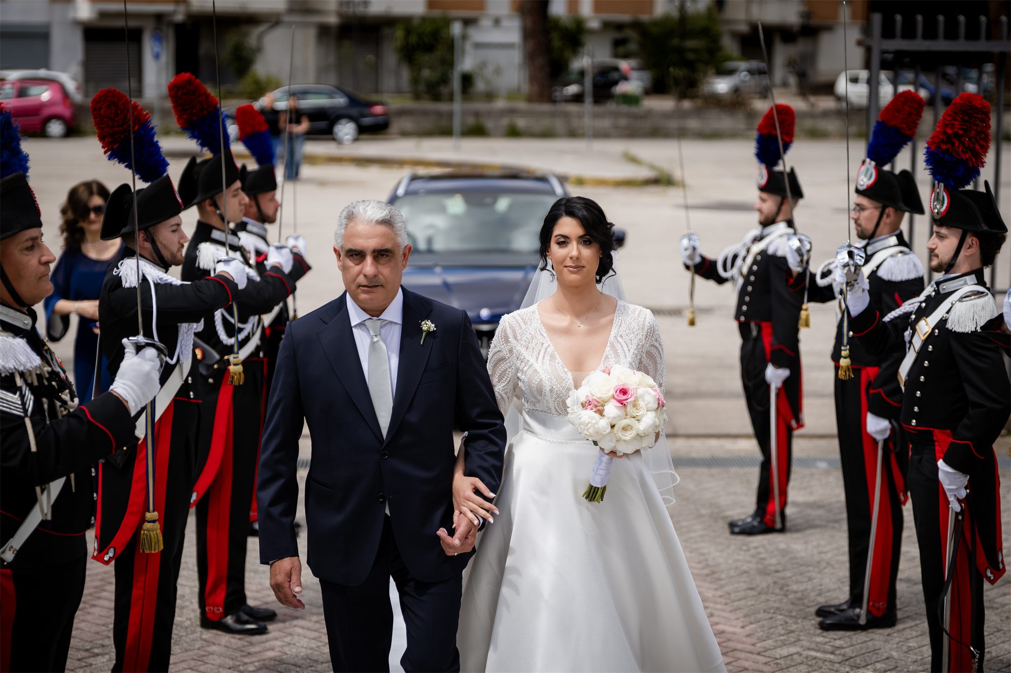 La sposa a braccetto con il papà avanza tra i carabinieri in alta uniforme