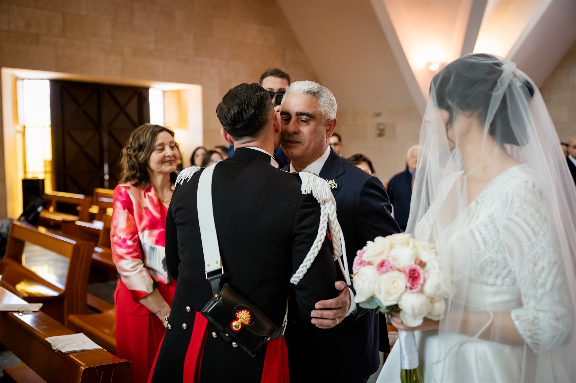 Lo sposo abbraccia il papà della sposa all'altare