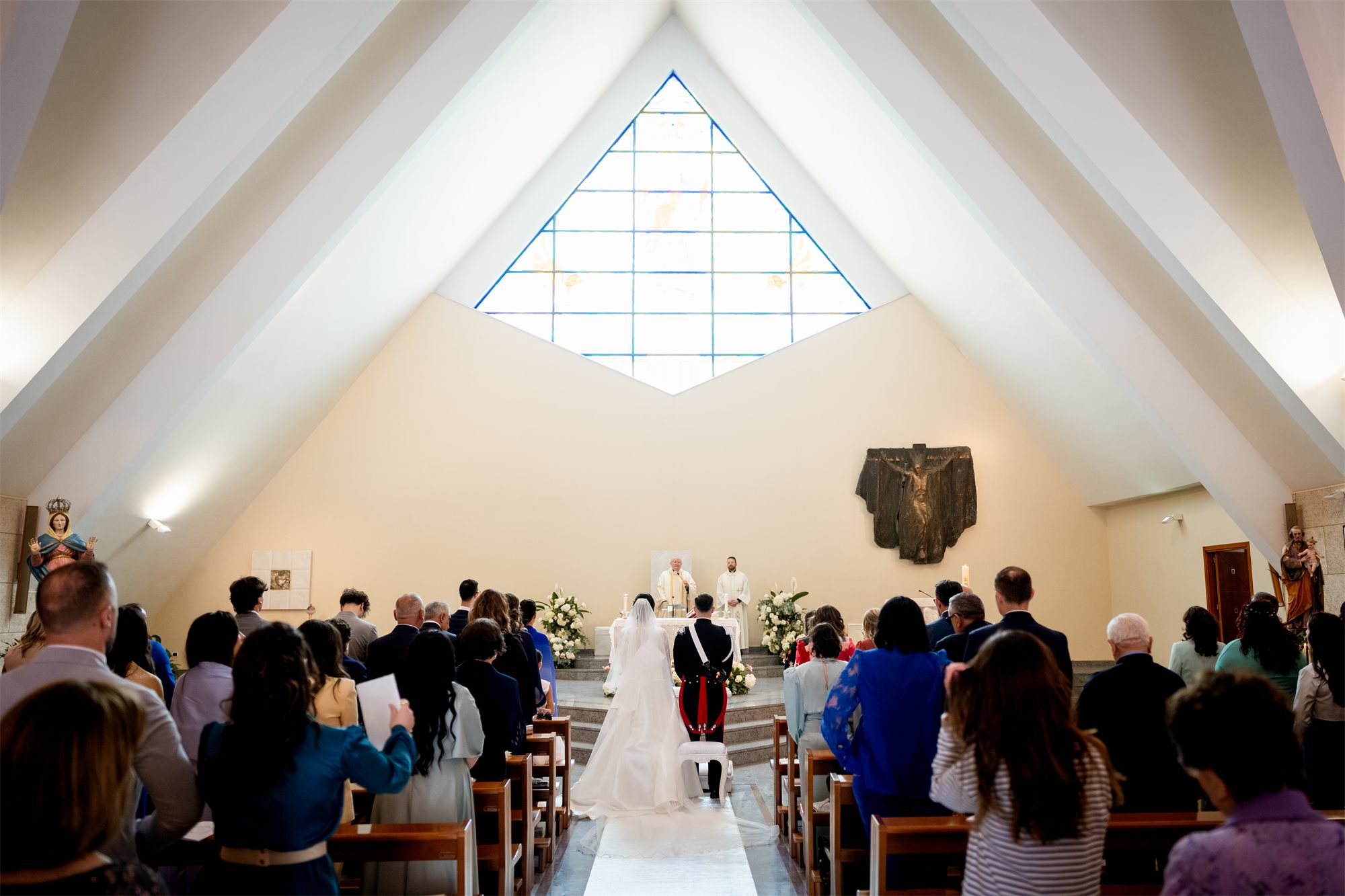 Veduta dell'interno della chiesa durante il matrimonio, con la grande finestra a punta