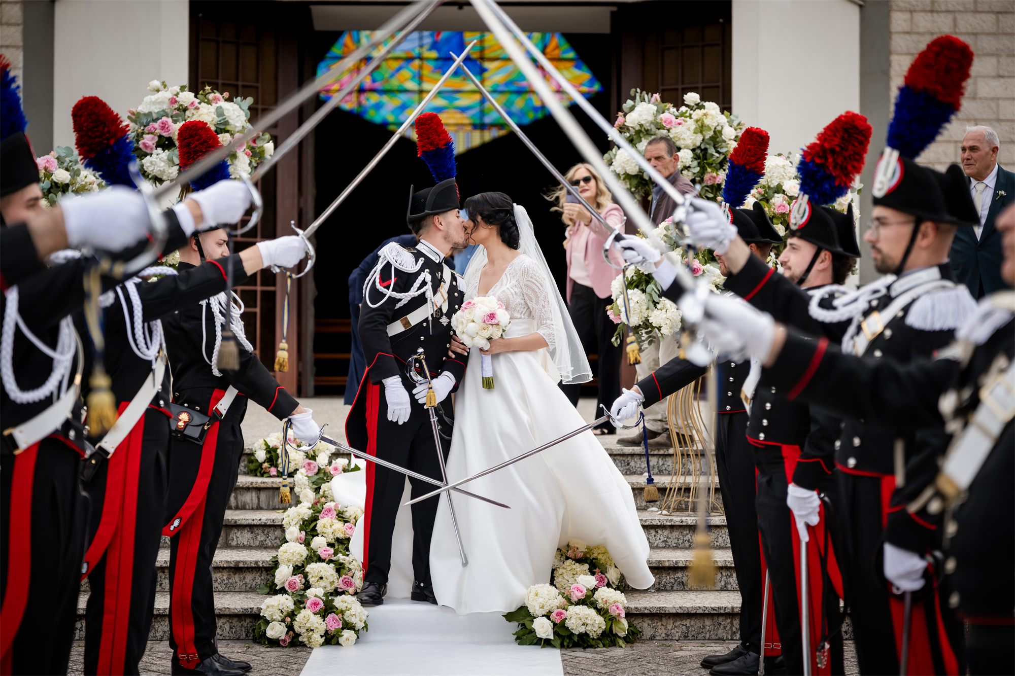 Il bacio degli sposi sotto le sciabole dei carabinieri, all'uscita dalla chiesa