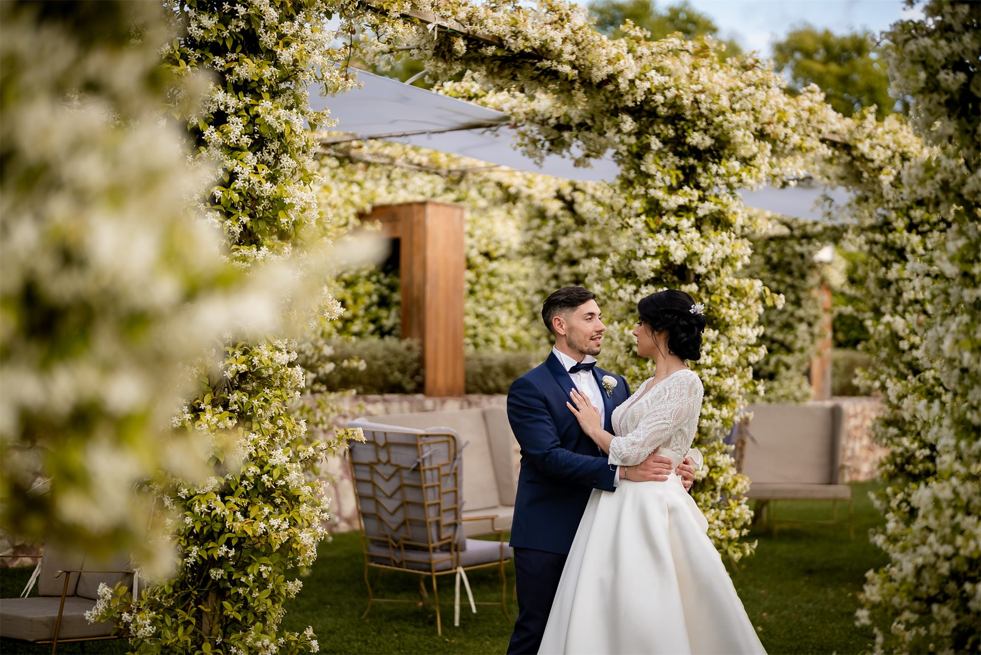 Gli sposi sotto la pergola di gelsomino nel giardino di Colle Rajano
