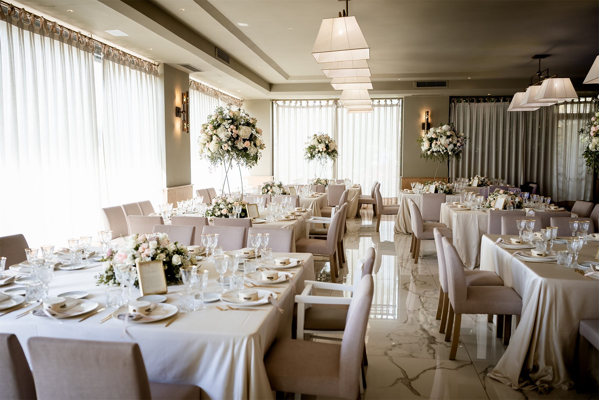 La sala ricevimenti di Colle Rajano con i tavoli apparecchiati e i fiori