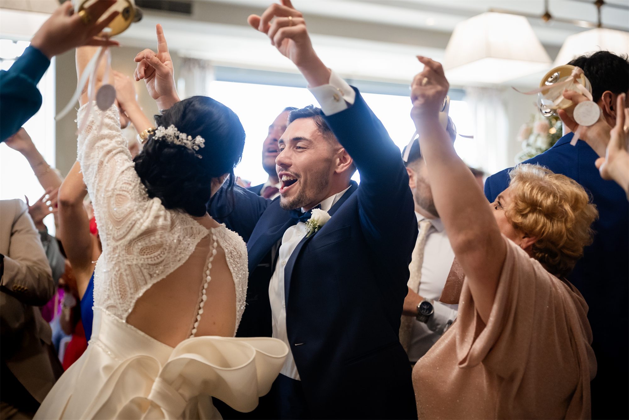 Gli sposi abbracciati in mezzo alla festa degli invitati a Colle Rajano
