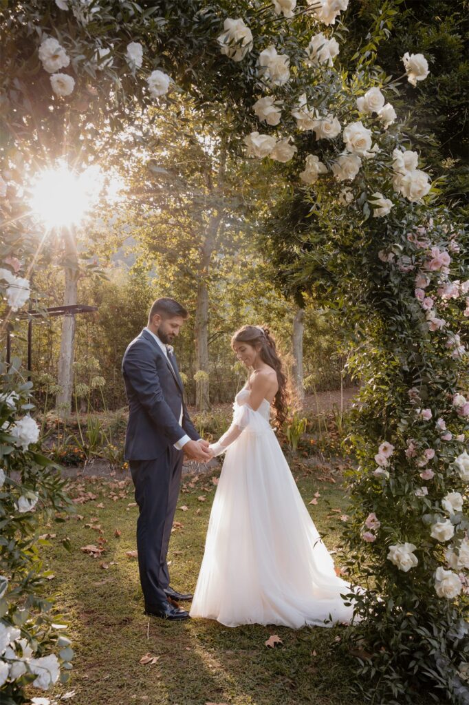 Gli sposi sotto l'arco di rose in controluce