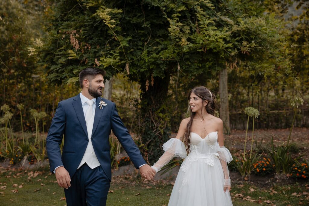 Fabio e Paola passeggiano mano nella mano nel giardino