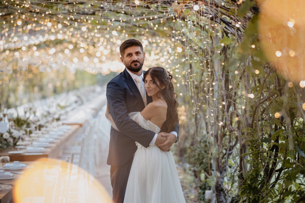 Fabio e Paola abbracciati nel pergolato di luci