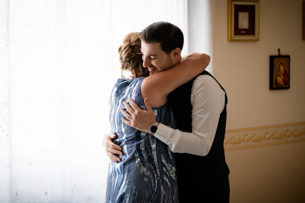 Lo sposo abbraccia la mamma prima di uscire