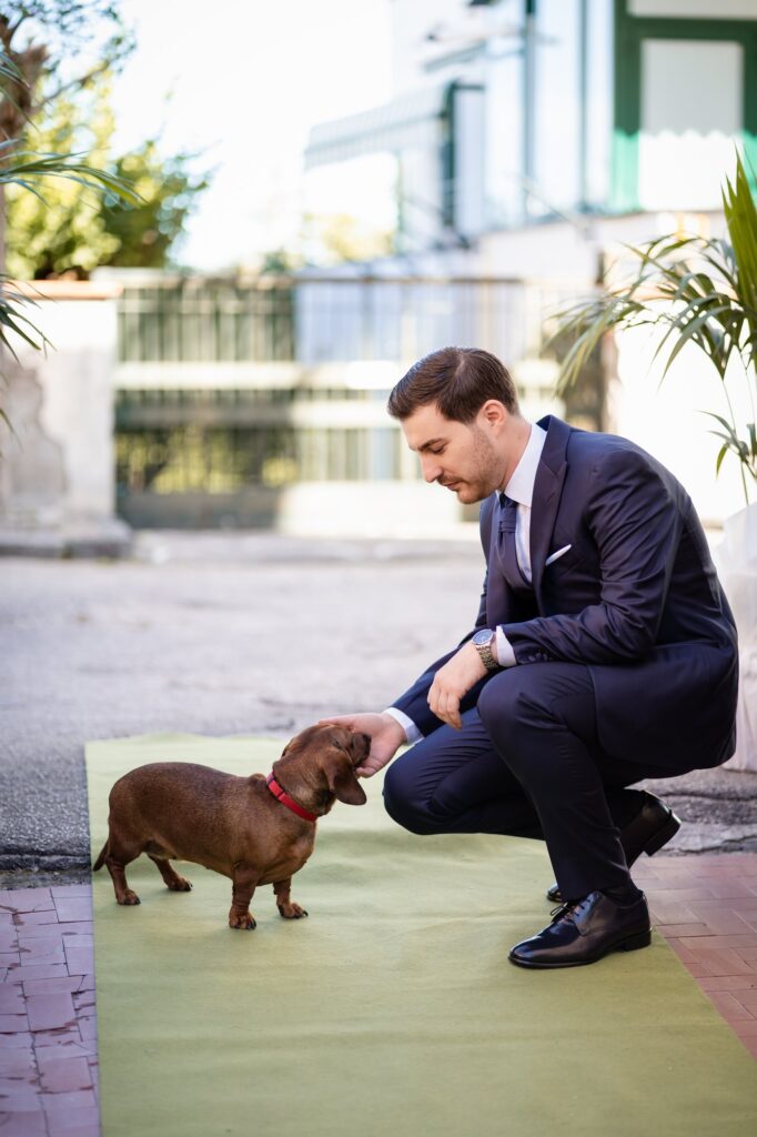 Lo sposo accarezza il cagnolino di casa