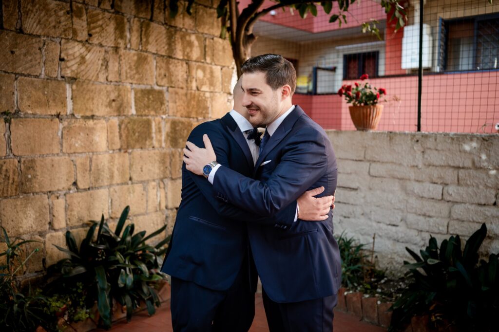 Abbraccio tra lo sposo e un amico
