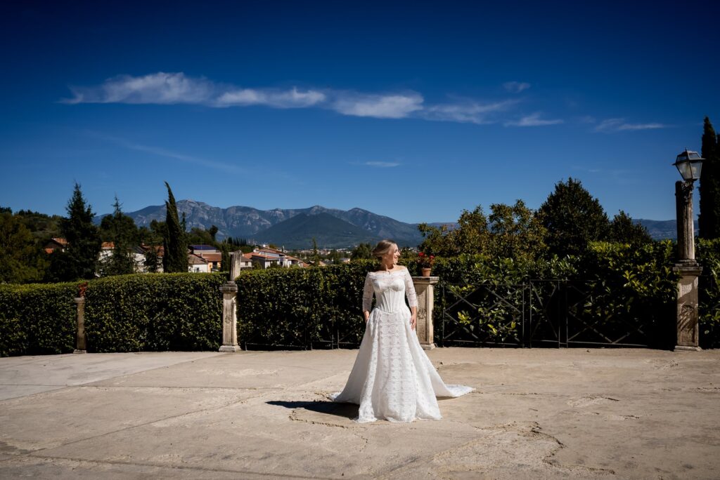 La sposa nel piazzale con le montagne alle spalle