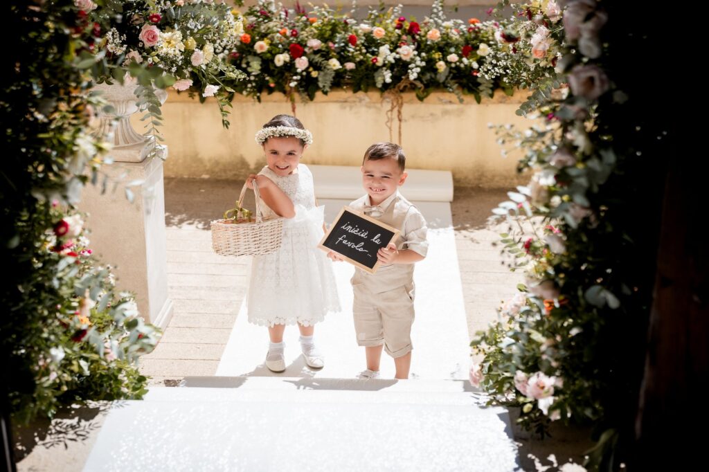 I piccoli paggetti sotto l'arco di fiori all'ingresso