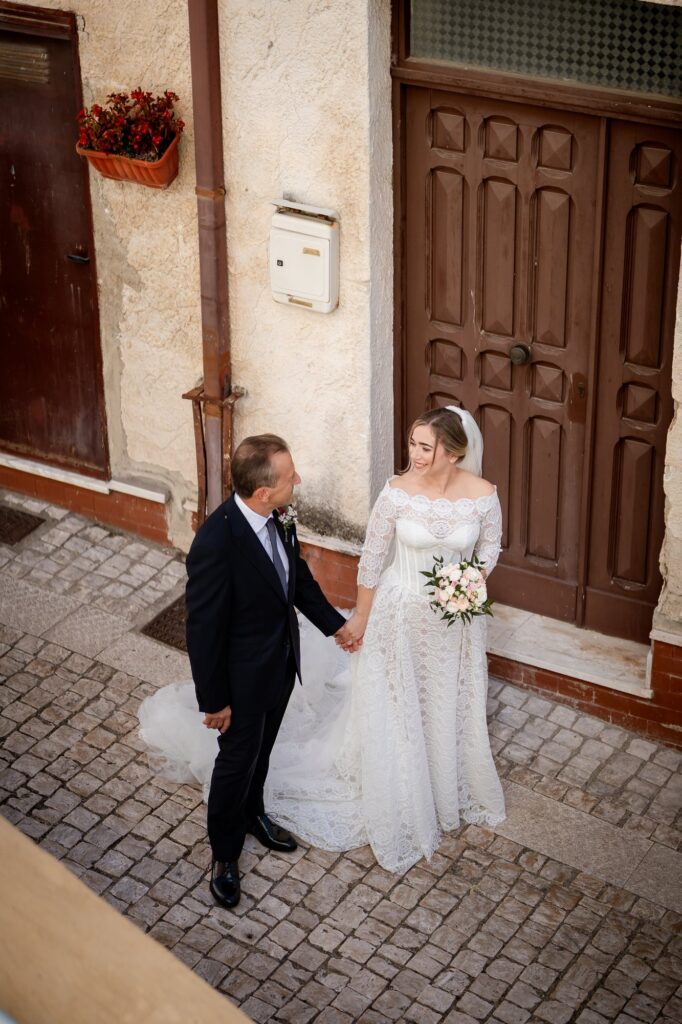 La sposa e il papà camminano nel vicolo verso la chiesa