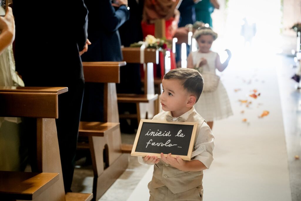 Un piccolo paggetto con il cartello all'ingresso in chiesa