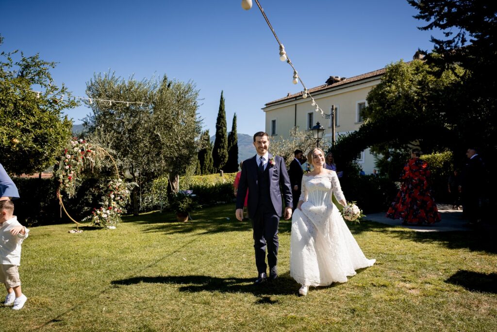 Gli sposi camminano sul prato davanti al Castello Ducale