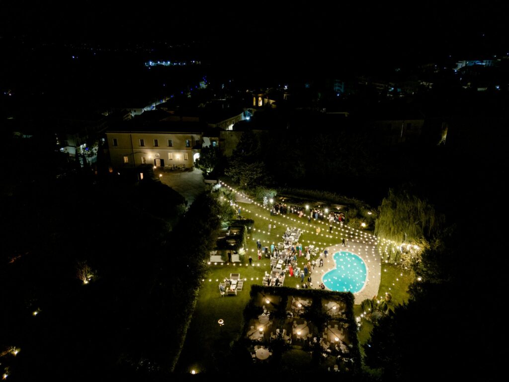 Il Castello Ducale e il giardino illuminati di notte, visti dall'alto