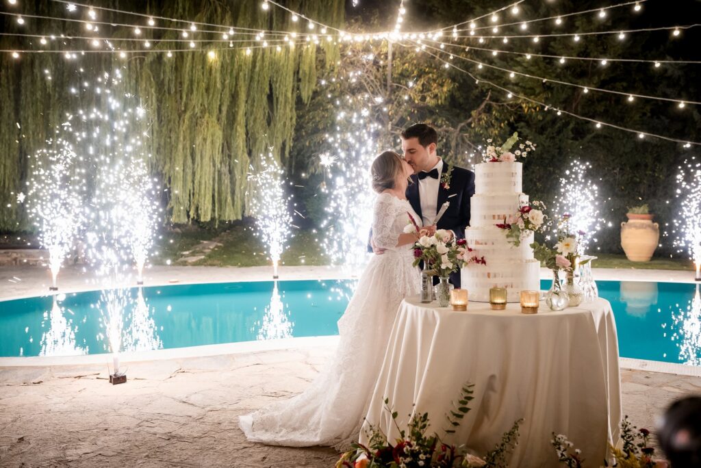 Gli sposi alla torta con la piscina illuminata