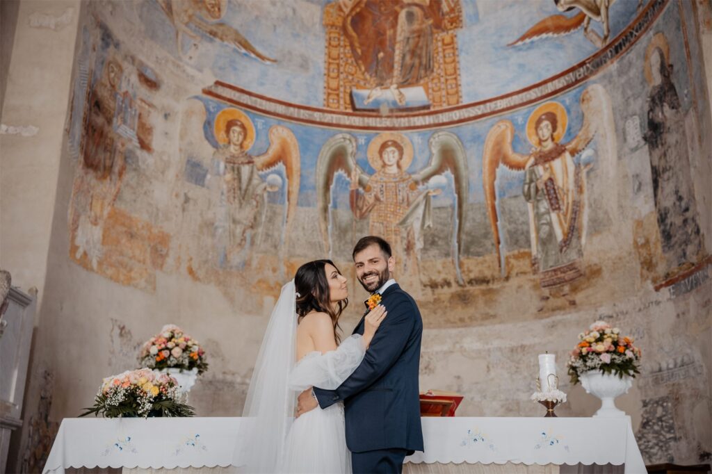 Gli sposi davanti all'abside affrescata della basilica