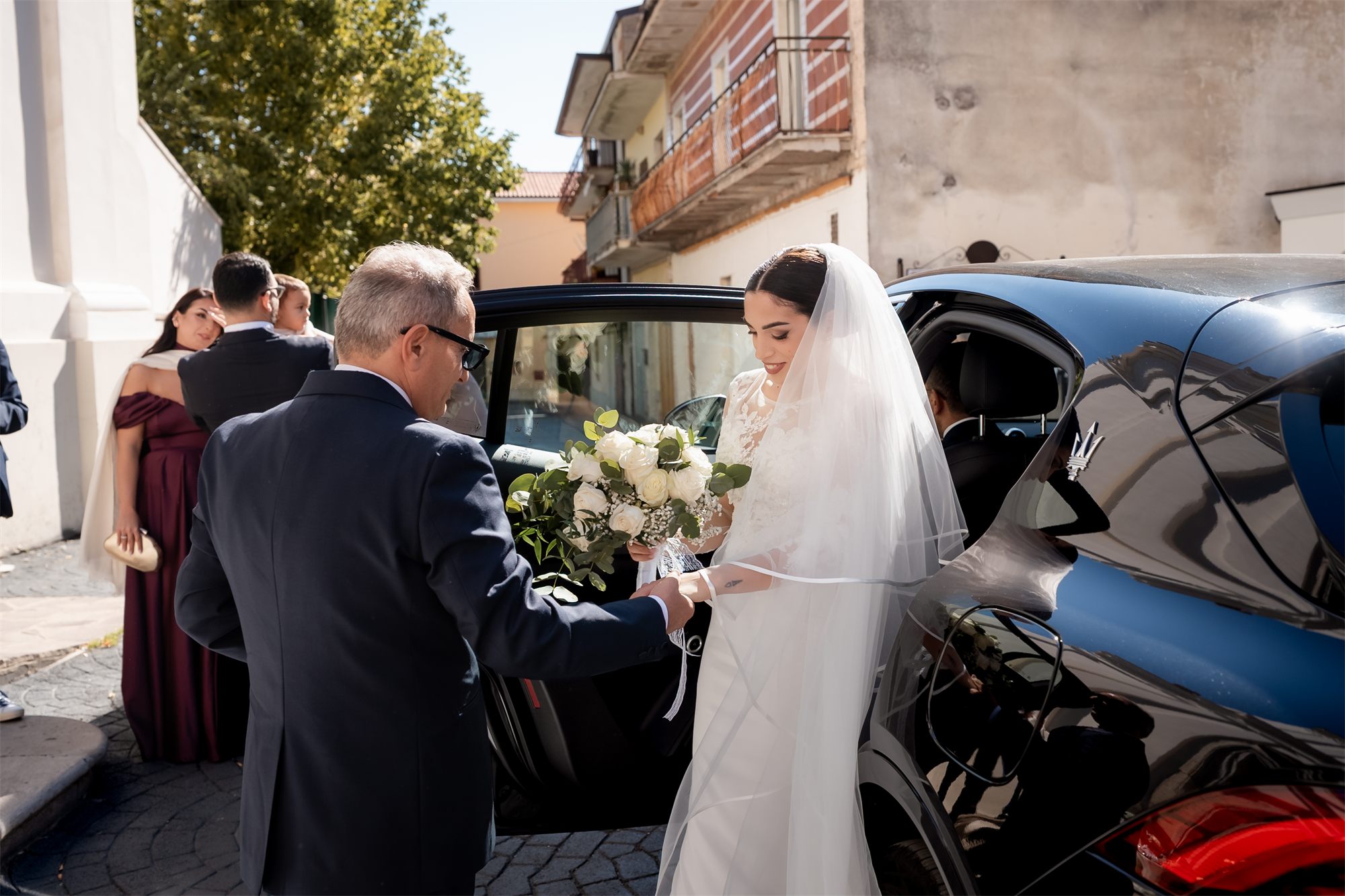 Il papà aiuta Teresa a scendere dall'auto davanti alla chiesa