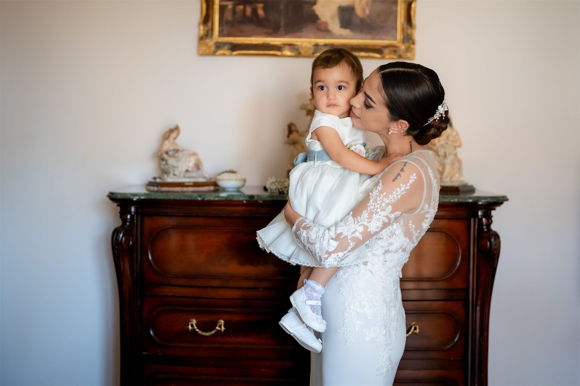 Teresa abbraccia la sua bambina in abito da sposa