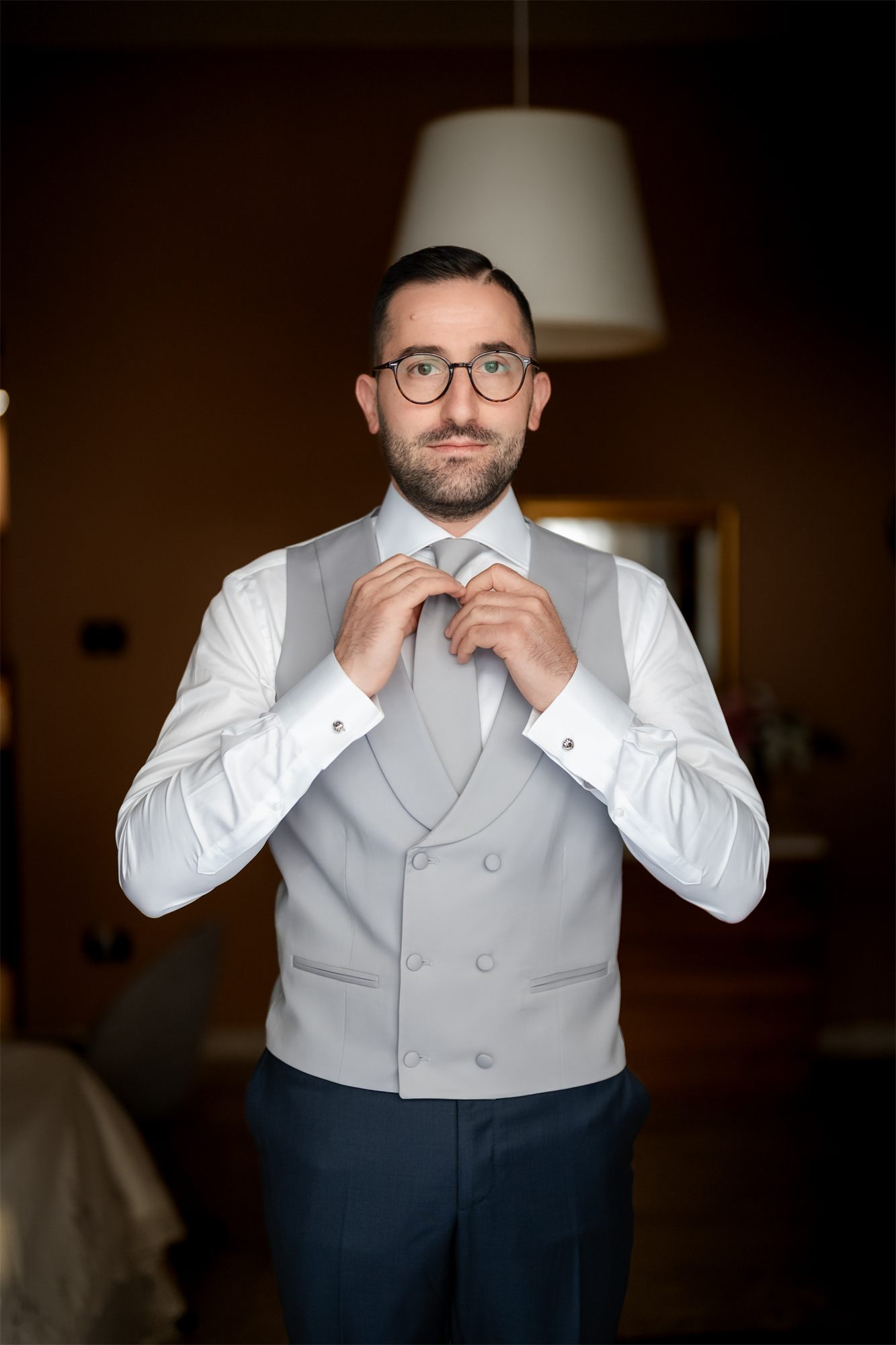 Marcello sistema il gilet grigio prima di vestirsi