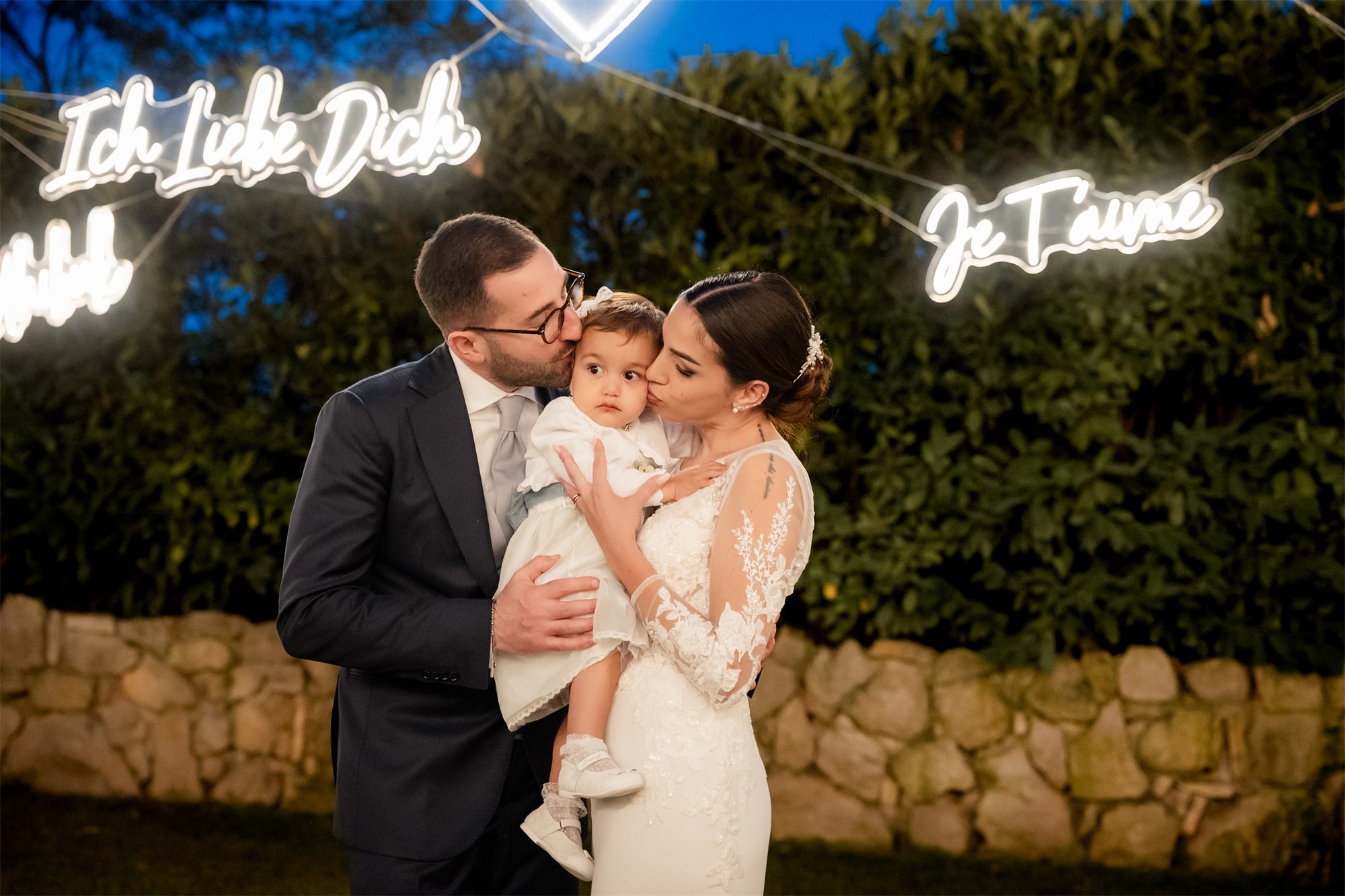 Marcello e Teresa con la bambina sotto le insegne al neon