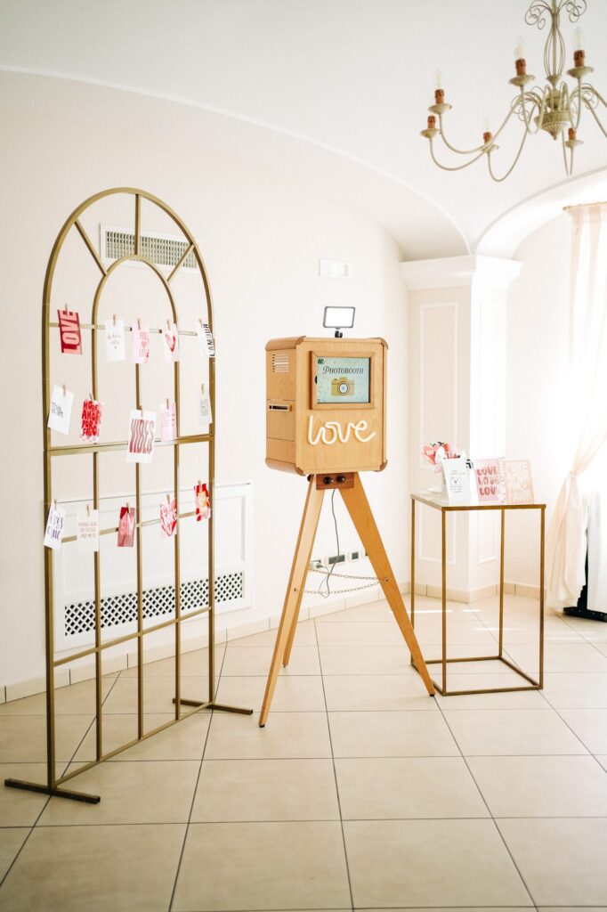 Il photobooth in legno con il fotomuro e le stampe appese