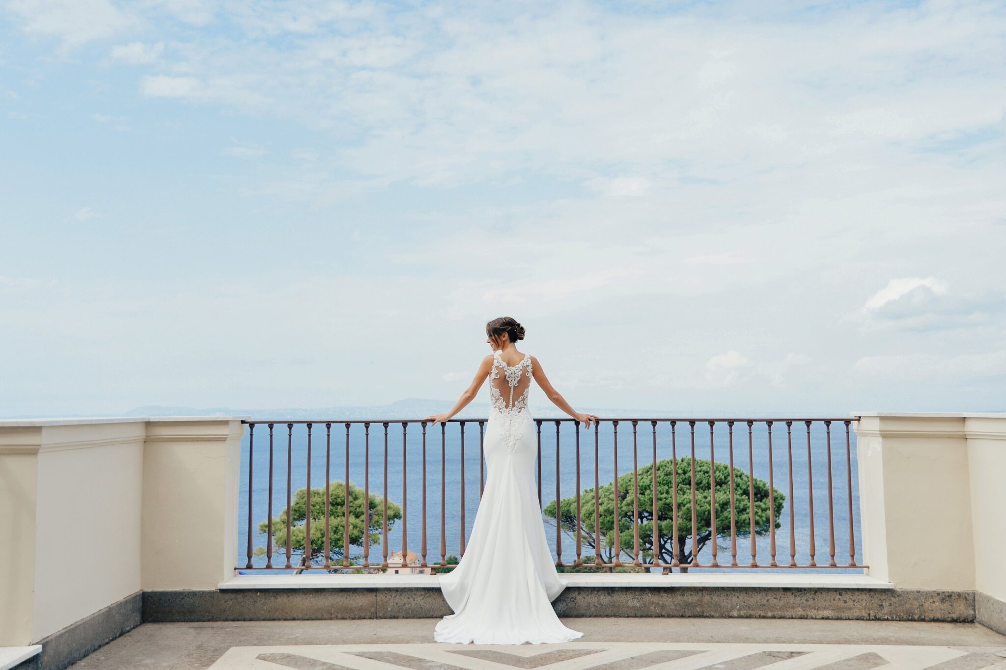La sposa di spalle su una terrazza affacciata sul mare, con il golfo di Napoli sullo sfondo