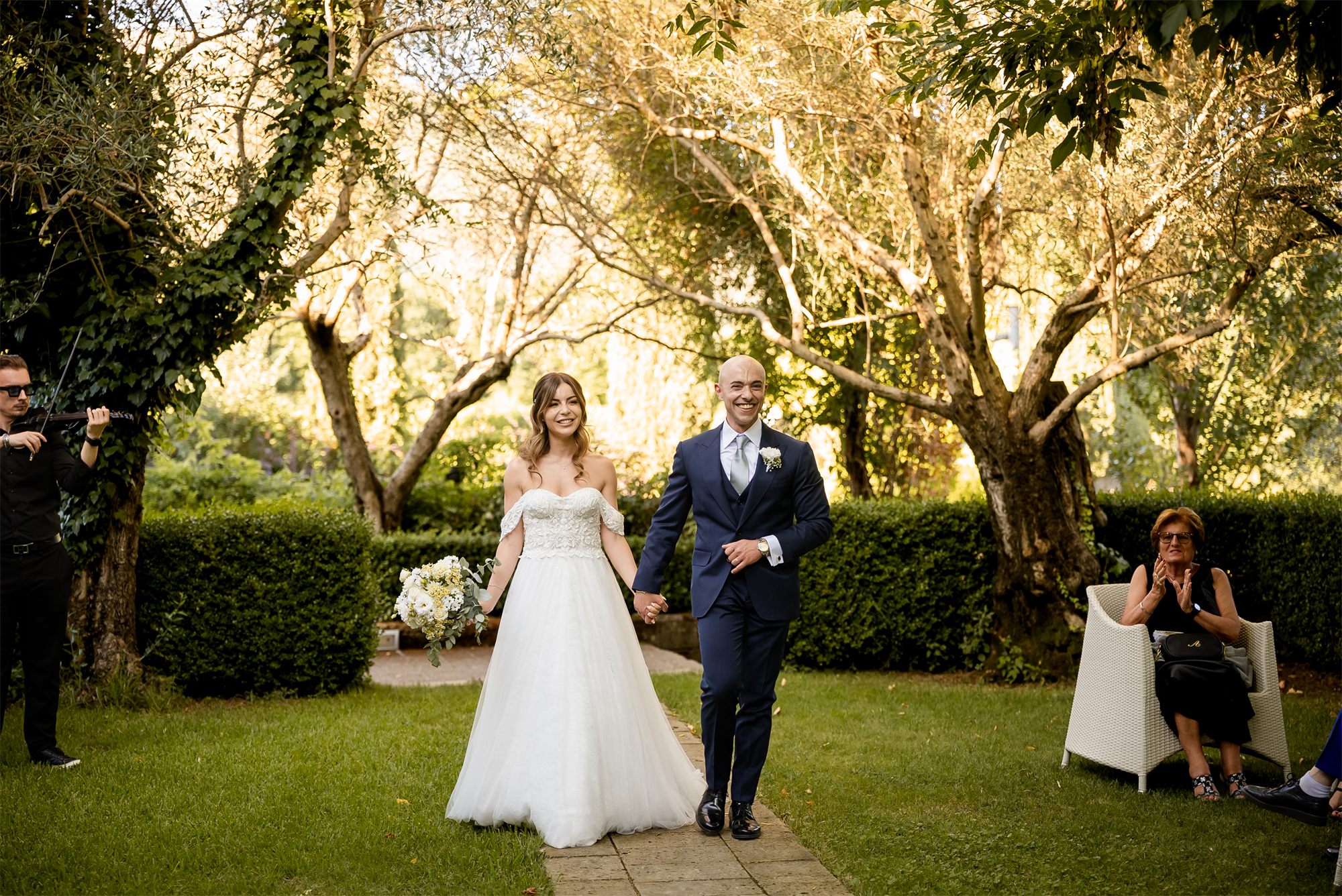 Stefano e Alessia camminano nel giardino verso il ricevimento a Tenuta Alois, Pontelatone (Caserta)