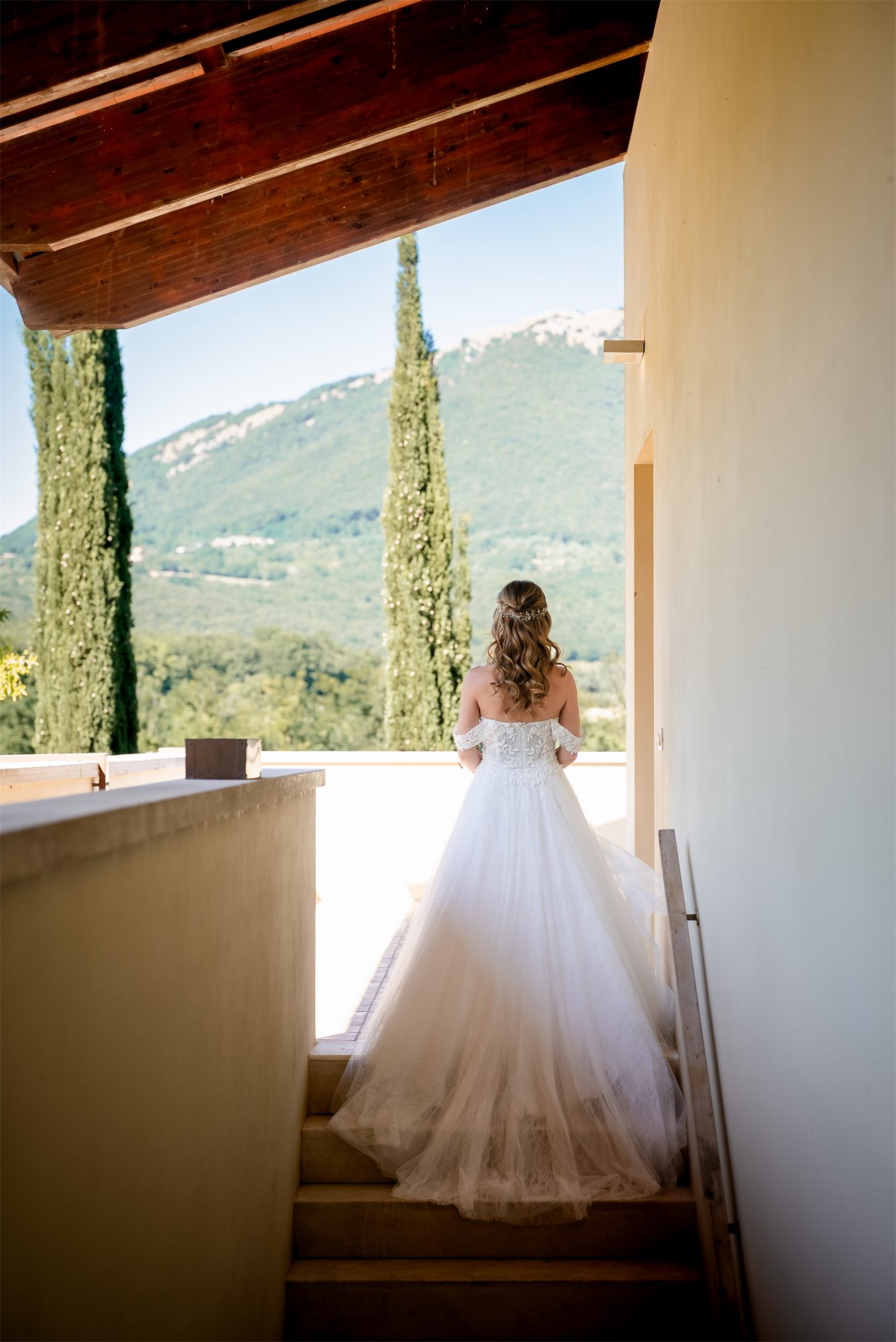 Alessia di spalle sale la scala con lo strascico dell'abito a Villa Paolina, Pontelatone (Caserta)
